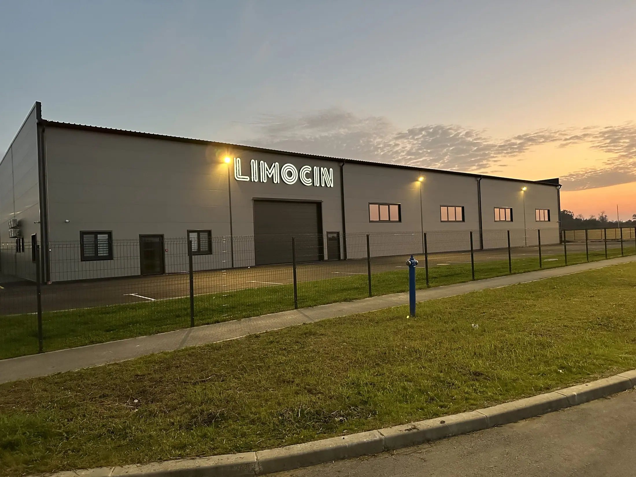 Proizvodna hala tvrtke Limocin s osvijetljenim natpisom u sumrak